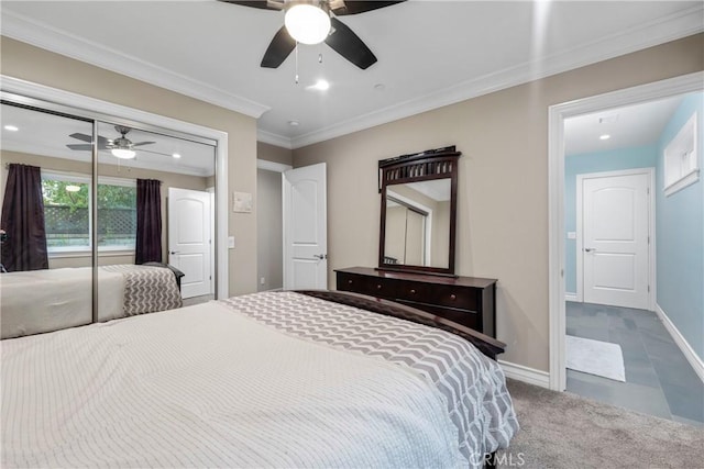 carpeted bedroom featuring ornamental molding, ceiling fan, and a closet