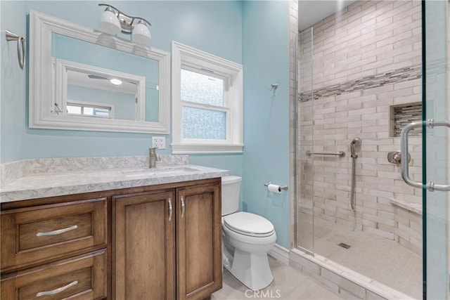 bathroom featuring vanity, an enclosed shower, and toilet