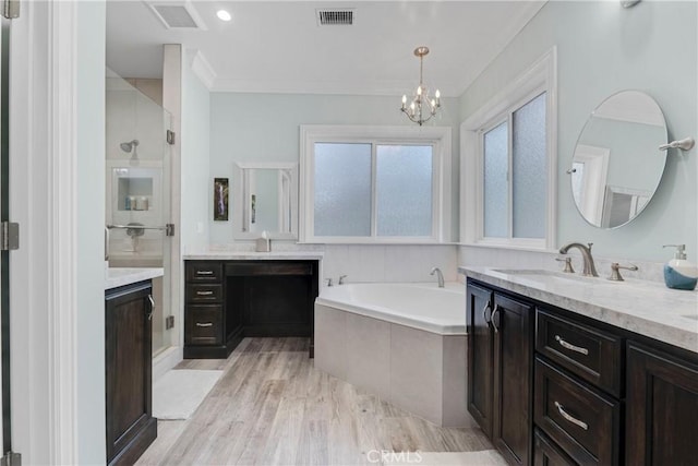 bathroom with vanity, hardwood / wood-style flooring, tiled bath, and an inviting chandelier