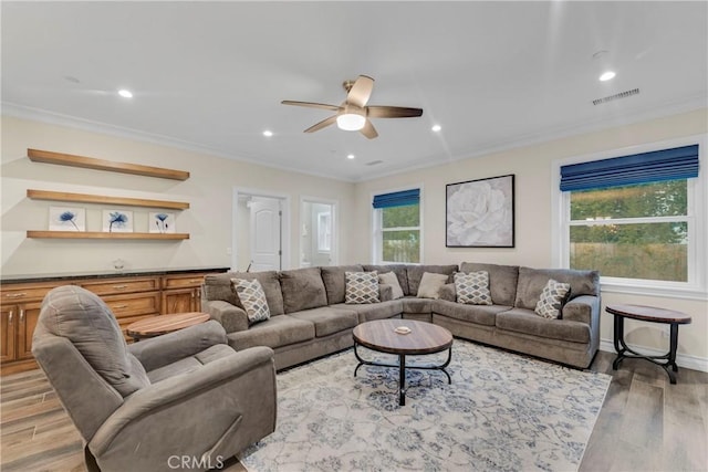 living room featuring crown molding, ceiling fan, and light hardwood / wood-style floors