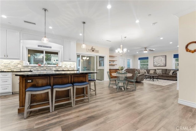 kitchen with white cabinetry, a breakfast bar, a center island, and hanging light fixtures