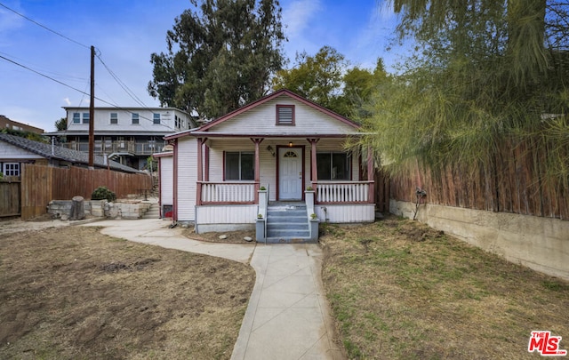 bungalow-style home featuring a porch and a front lawn