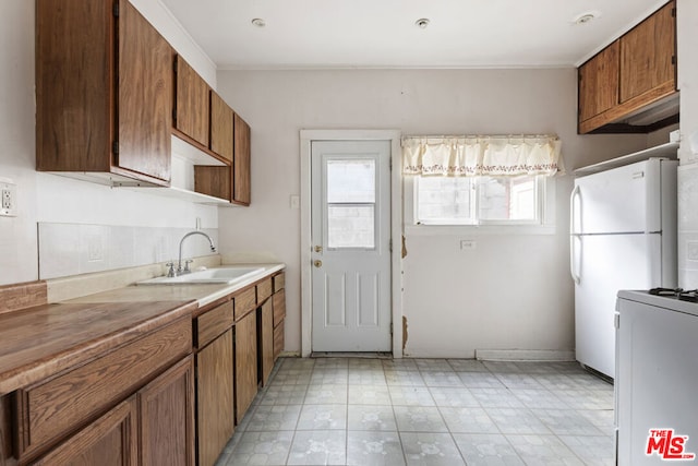 kitchen with white refrigerator, sink, and a wealth of natural light