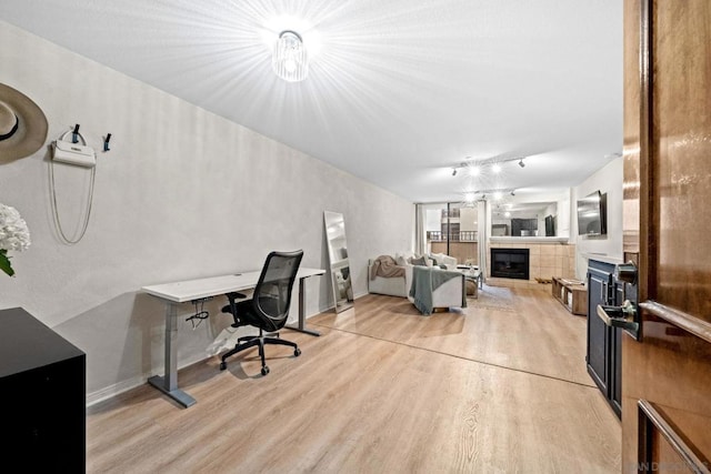 office with a fireplace and light hardwood / wood-style flooring