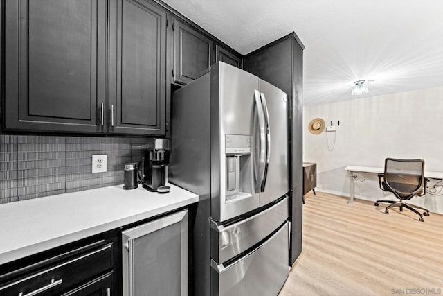 kitchen with light hardwood / wood-style floors, stainless steel fridge, beverage cooler, and decorative backsplash