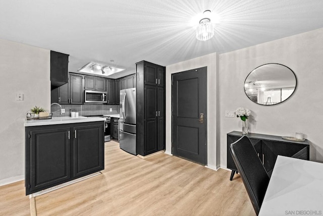 kitchen with stainless steel appliances, tasteful backsplash, and light hardwood / wood-style floors