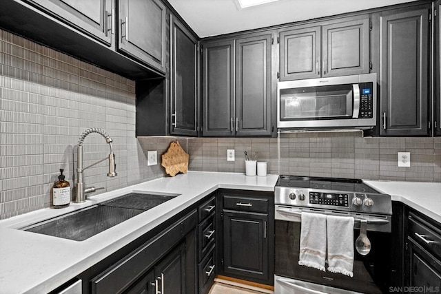 kitchen featuring tasteful backsplash, appliances with stainless steel finishes, and sink