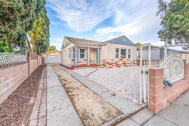 bungalow-style home with a garage, an outbuilding, and covered porch