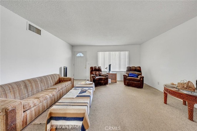 living room with visible vents, carpet floors, and a textured ceiling