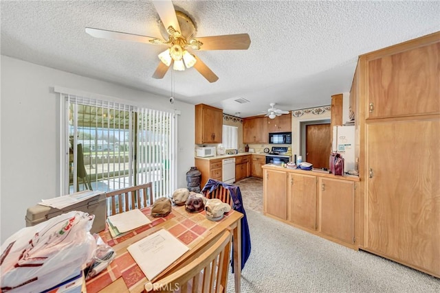 dining room with ceiling fan, light colored carpet, and a textured ceiling