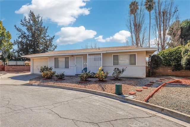 ranch-style home with a garage, stucco siding, and concrete driveway