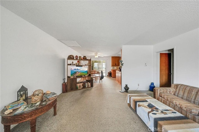 living area featuring a textured ceiling, light colored carpet, and ceiling fan