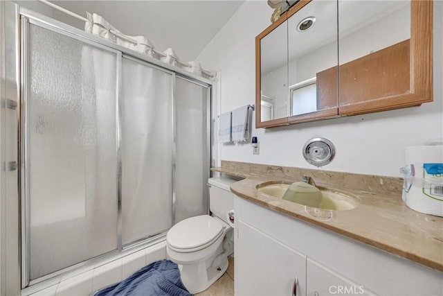 bathroom featuring vanity, toilet, a stall shower, and tile patterned floors