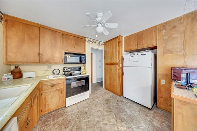 kitchen featuring electric range oven, sink, white refrigerator, tile counters, and ceiling fan