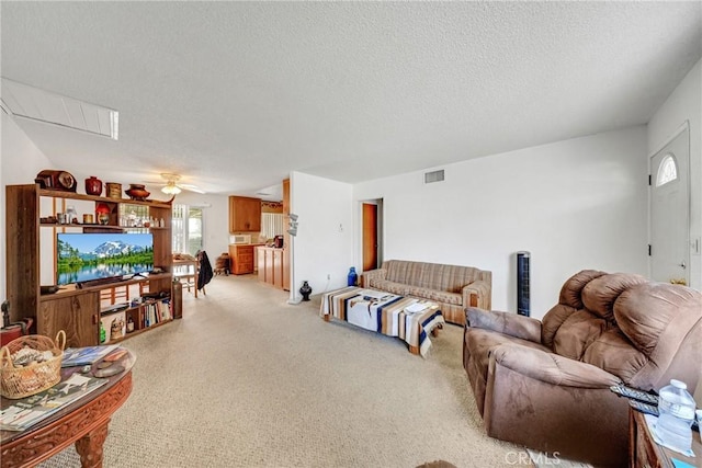 living room with ceiling fan, carpet flooring, and a textured ceiling