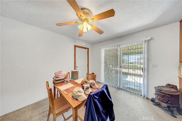 dining room with ceiling fan, carpet flooring, and a textured ceiling