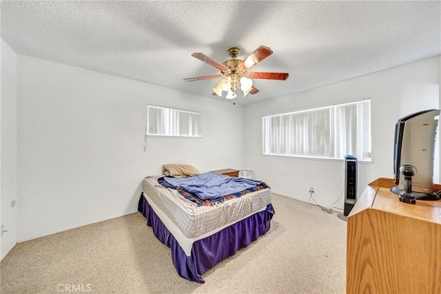 bedroom featuring carpet, a textured ceiling, and a ceiling fan