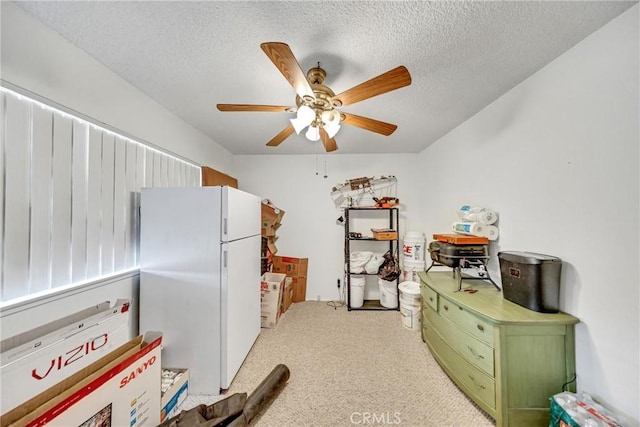 kitchen featuring light carpet, a textured ceiling, green cabinets, white fridge, and ceiling fan