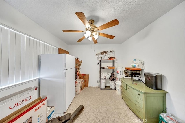 kitchen featuring a textured ceiling, freestanding refrigerator, carpet, green cabinets, and ceiling fan