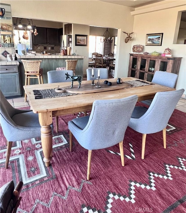 dining area featuring an inviting chandelier and light tile patterned floors