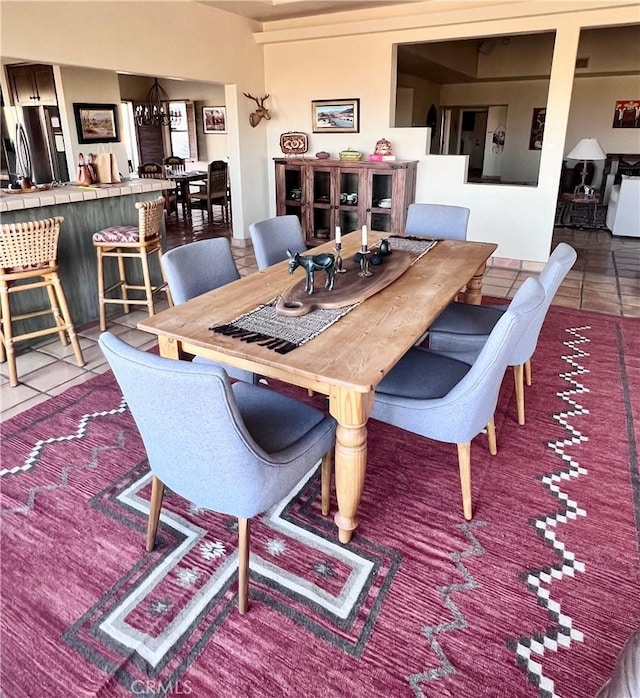 dining area featuring tile patterned flooring and an inviting chandelier