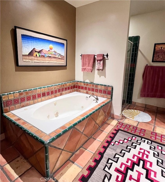 bathroom with tiled bath and tile patterned flooring