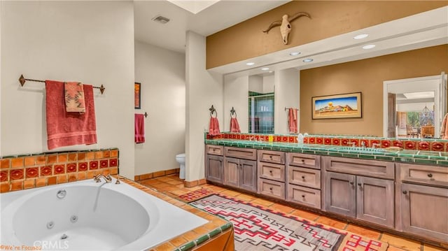 bathroom with double vanity, visible vents, toilet, tile patterned flooring, and a tub with jets