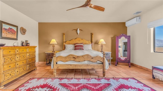 bedroom with light tile patterned floors, baseboards, a ceiling fan, and a wall mounted AC