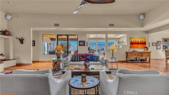 tiled living room featuring baseboards, visible vents, and a ceiling fan