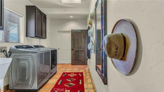 laundry area with light tile patterned flooring, washing machine and dryer, and cabinet space