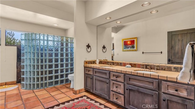 full bathroom with tile patterned floors, a sink, toilet, and double vanity