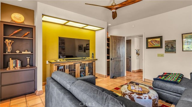 living area featuring light tile patterned floors, ceiling fan, built in features, and baseboards