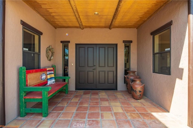 property entrance with a patio and stucco siding