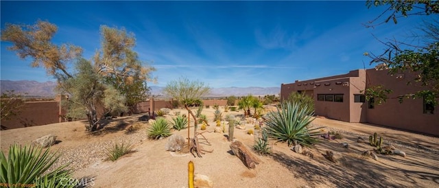 view of yard featuring fence and a mountain view