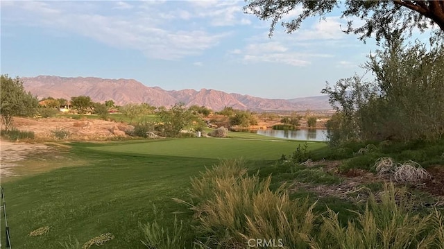 property view of mountains featuring view of golf course and a water view