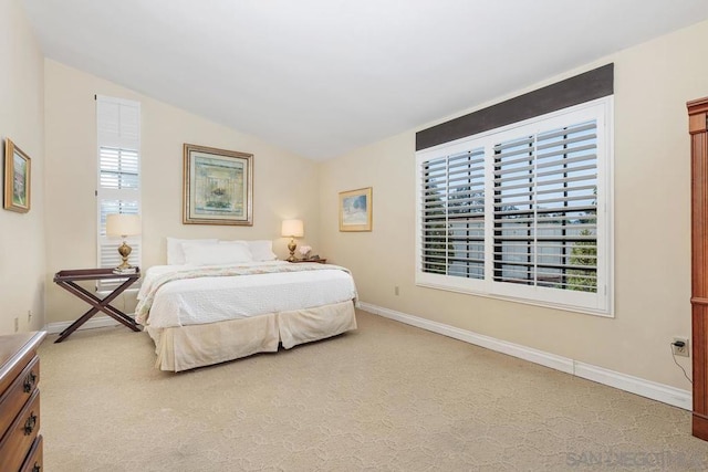 carpeted bedroom with multiple windows and vaulted ceiling