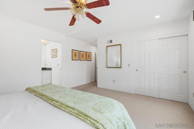 bedroom featuring light carpet, ceiling fan, and a closet