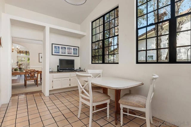 dining space featuring light tile patterned floors and a notable chandelier