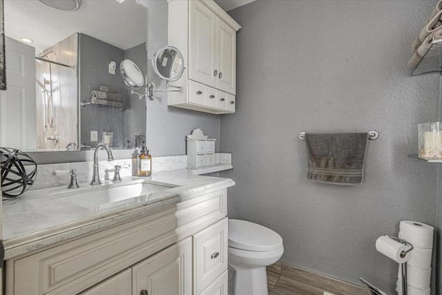 bathroom with vanity, toilet, and wood-type flooring