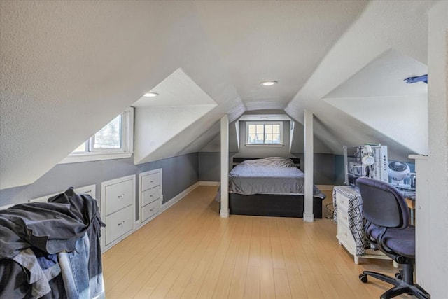 bedroom with vaulted ceiling and light hardwood / wood-style floors