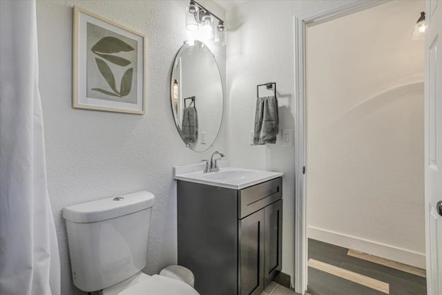 bathroom featuring vanity, hardwood / wood-style floors, and toilet