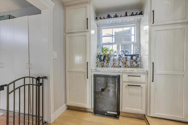 kitchen featuring beverage cooler and light hardwood / wood-style flooring