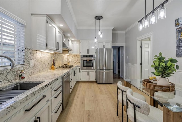 kitchen featuring sink, white cabinetry, light stone counters, pendant lighting, and stainless steel appliances