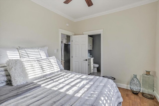 bedroom with crown molding, ensuite bath, hardwood / wood-style flooring, stainless steel refrigerator, and ceiling fan