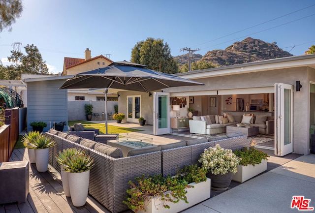 rear view of house with outdoor lounge area, a deck with mountain view, and a patio area