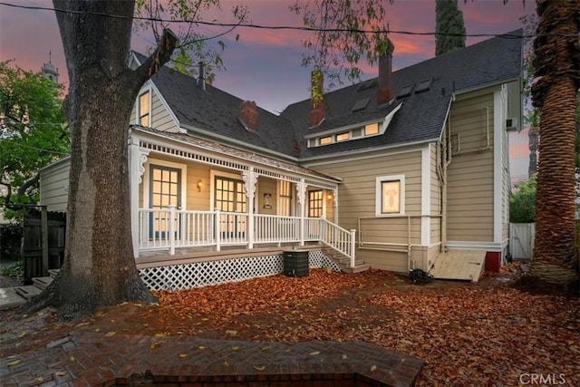 back house at dusk with covered porch