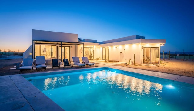 pool at dusk with a patio