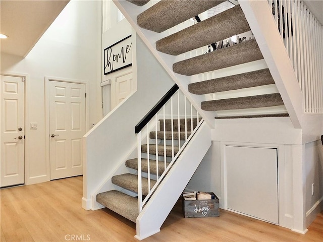 staircase featuring hardwood / wood-style flooring and a towering ceiling