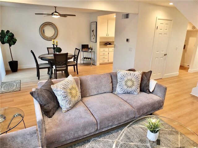 living room with ceiling fan and light hardwood / wood-style floors