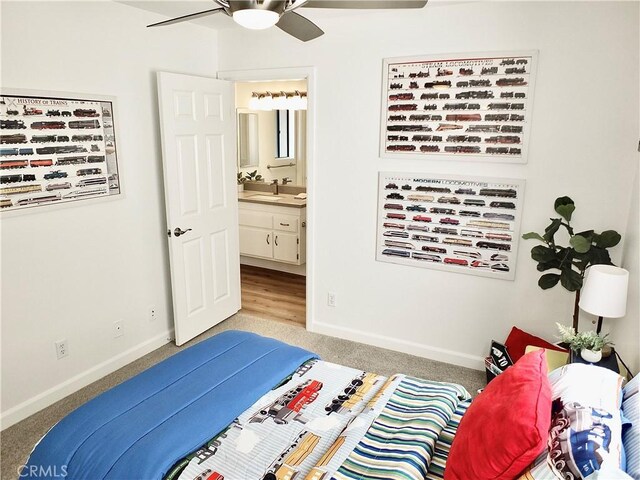 carpeted bedroom with ceiling fan, ensuite bath, and sink